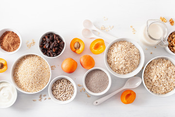variaty of raw cereals, fruits and nuts for breakfast. Oatmeal flakes and steel cut, barley, walnut, chia, apricot. Healthy ingredients