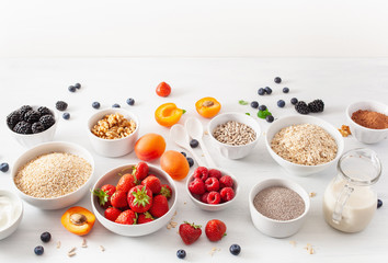 variaty of raw cereals, fruits and nuts for breakfast. Oatmeal flakes and steel cut, barley, walnut, chia, apricot, strawberry. Healthy ingredients