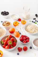 variaty of raw cereals, fruits and nuts for breakfast. Oatmeal flakes and steel cut, barley, walnut, chia, apricot, strawberry. Healthy ingredients