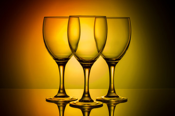 three empty glasses on a yellow background