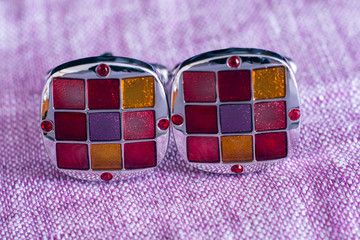 beautiful cufflinks on lilac fabric
