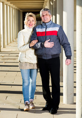 Married couple goes for walk between concrete pillars