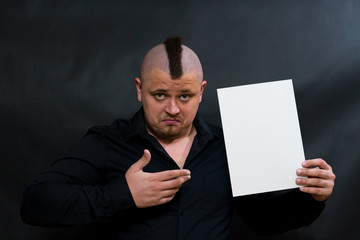 Naklejka premium Iroquois. In the young man left hand is a clean white sheet. The right hand points to the sheet. The face reflects stubbornness and question. copy space