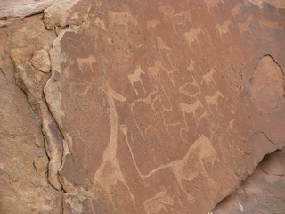 Ancient rock engravings, including depictions of animals such as giraffe, cattle, zebra, and a lion, at Twyfelfontein, Namibia, a UNESCO World Heritage Site
