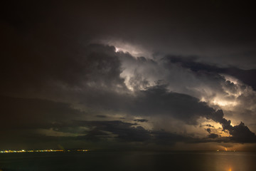 Naklejka na ściany i meble Thunderstorm over the sea, lightning beats the water