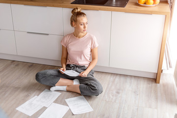 young pensive woman thinking about her debt. problems with money. close up side view photo