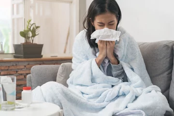 Fotobehang Sick day at home. Asian woman has runny and common cold. © Pormezz