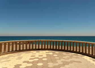 Antique balcony with sea view over background, view of the sea on a hot day