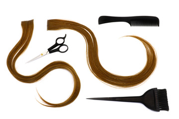 a strand of brown hair, brushes, scissors, comb, hairdressing tools on a white background, isolated