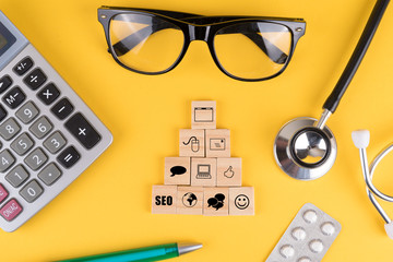 Online-Marketing Komponenten als Symbole auf Würfeln in der Arztpraxis