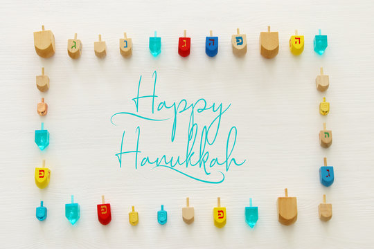 Image of jewish holiday Hanukkah with wooden dreidels colection (spinning top) over white background.