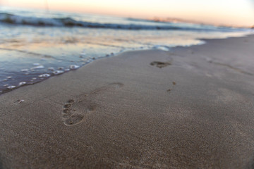 Fototapeta na wymiar Coastline of the beach with footprint on the unfocused background