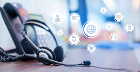 close up soft focus on headset with telephone devices at office desk for customer service support with communication icon technology concept © chinnarach