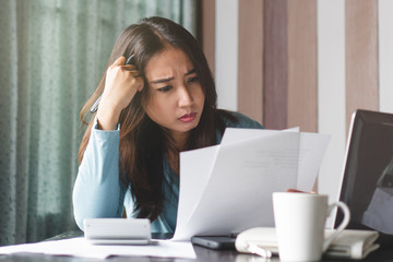 stressed young asian woman trying to find money to pay credit card debt.