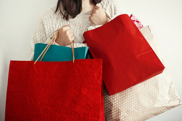 Christmas Shopping and seasonal sale. Happy Girl holding colorful shopping bags on white...