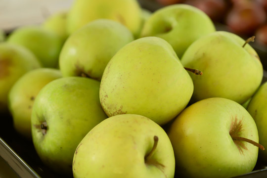 Green apples. Background. Cropped snapshot. Image of fruit in a store or buffet. The concept of proper nutrition.