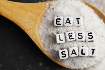 Eat less salt in order to reduce blood pressure or hypertension risk with sprinkled salt on dark...
