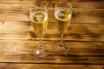 Two glasses of champagne on wooden table