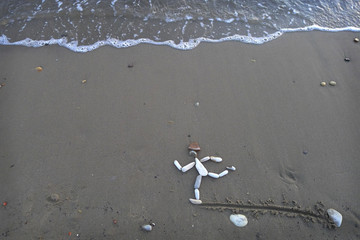Figure Of Running Man Made Of Stones On Sand © andrei_sikorskii