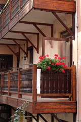 Fototapeta na wymiar Balcony made of wood, with red flowers