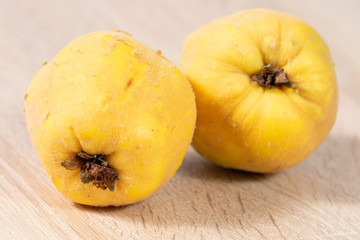 Close up of yellow quinces on wooden background in the kitchen 