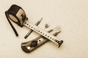 Table composition with roulette, pencil, cleric knife and shavings in sepia tones. Monochrome...