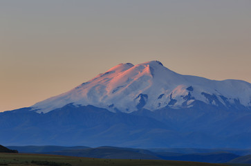 Mount Elbrus at dawn. View of the sunlit slopes of the volcano from the northwest. The North Caucasus in Russia.