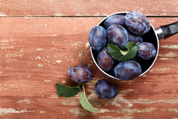ripe plums in a saucepan on the table