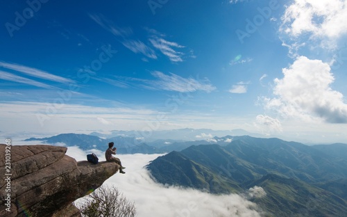 Young man sitting at the edge of the cliff