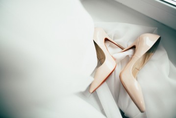 Close up of white high heels on wedding dress