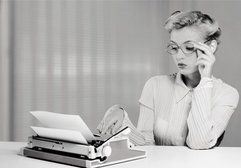 Fototapeta premium Young secretary with phone and typing machine