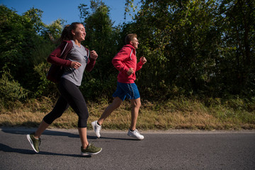 young couple jogging along a country road