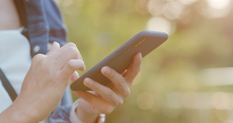 Woman use of mobile phone in city with sunset