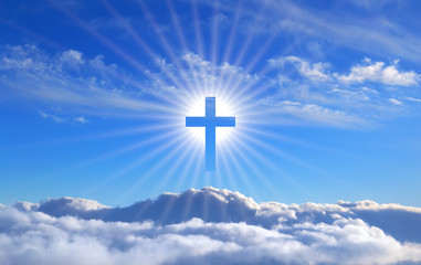 religious cross over cumulus clouds illuminated by the rays of holy radiance, concept