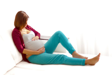 Pregnant caucasian woman relaxing at home on the couch