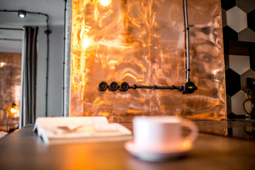 Coffee and magazine on the kitchen table at the modern loft interior