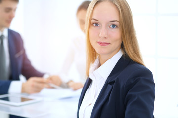 Group of business people or lawyers discussing terms of transaction in office. Focus at young business woman. Meeting and teamwork concept