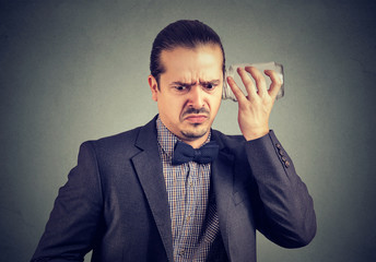 Annoyed man eavesdropping with glass jar