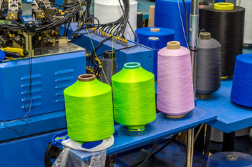 Spools with colored threads on a machine for knitting socks