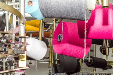 Spools with colored threads on a machine for knitting socks