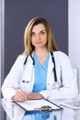 Woman doctor at work in hospital office. Portrait of female physician. Medicine and health care concept