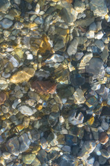 sea pebble beach with multicoloured stones, waves with foam