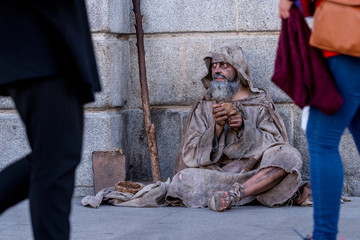 Ragged beggar begging on the street