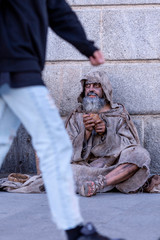 Ragged beggar begging on the street