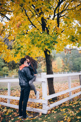 Fototapeta premium Romantic holidays guy and girls in autumn park. Funny games of husband and wife in nature.