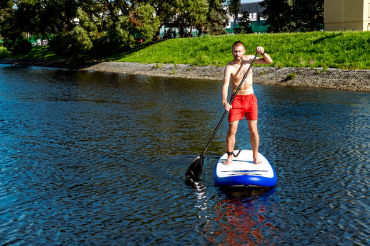 man riding a sup board on the water Rowing canal in St. Petersburg