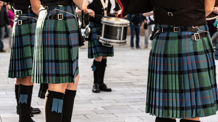 Schottische Jugendliche mit Kilt, Dudelsack und Trommel musizieren auf dem Dorfplatz