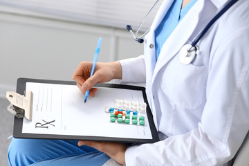 Woman doctor at work at hospital. Young female physician write prescription or filling up medical form while sitting in hospital office, close-up