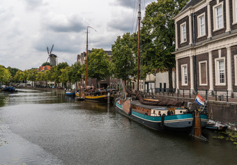 Traditional wooden sailing ships in water channel. Old historic harbor of Schiedam, The Netherlands