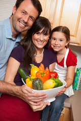Happy Family Holding Vegetables in Kitchen at Home